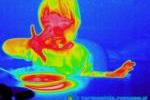 Dziecko jedzące kisiel w termowizji. Na powierzchni stolika widoczne odbicie termoczne talerza.